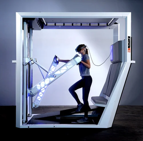 Ethereal Matter MEK in use - person wearing VR headset interacting with the lit force-feedback armature inside the full platform unit